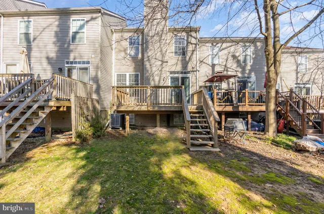 a view of residential houses with cars parked in front of a house