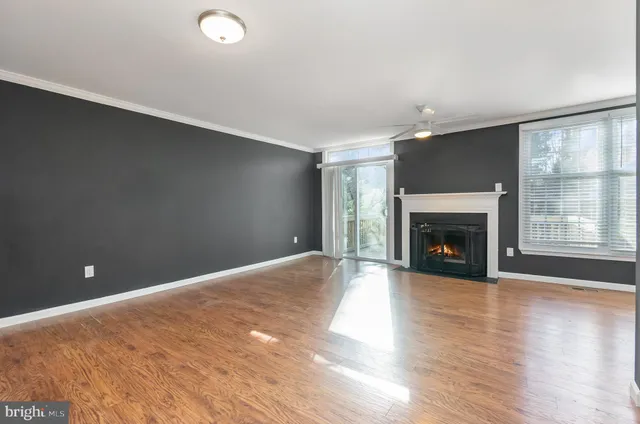 a view of empty room with wooden floor and fireplace