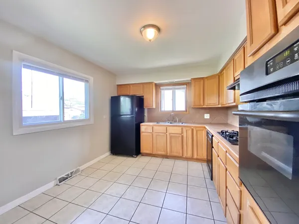 a kitchen with stainless steel appliances granite countertop a stove a sink and a refrigerator