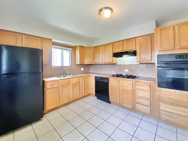 a kitchen with a sink window and cabinets