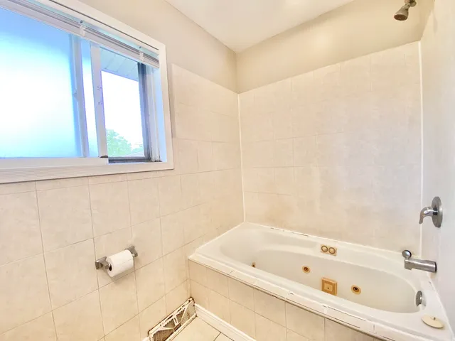 a bathroom with a tub sink and window