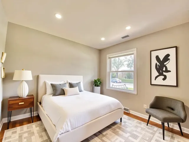 a bedroom with a large bed and a chair