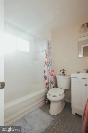 a white toilet sitting next to a bath tub