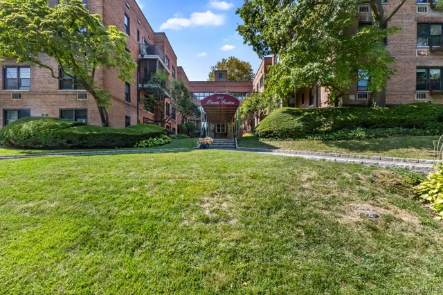 a view of a house with a big yard and large trees