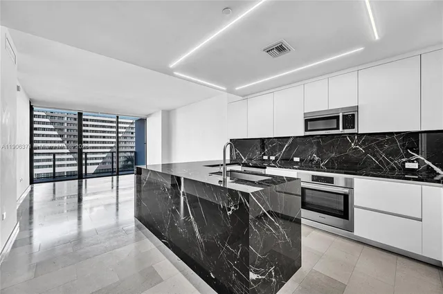 a kitchen with stainless steel appliances granite countertop a stove a sink and a microwave