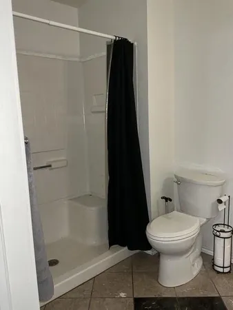 a white toilet sitting next to a shower