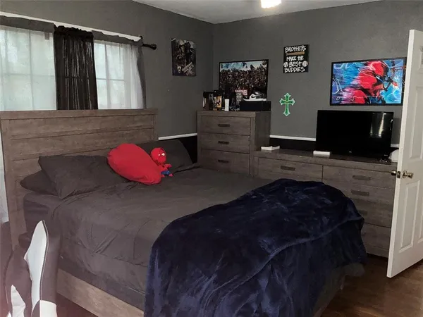 a bedroom with a bed and a flat screen tv