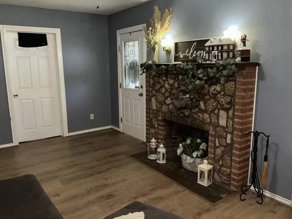 a view of an empty room with fireplace and hallway