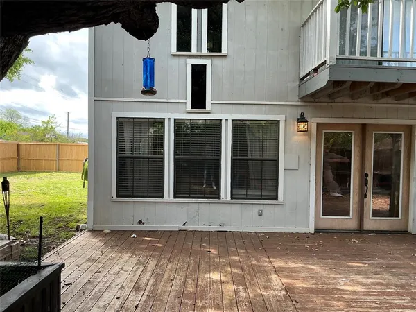 a view of a backyard with a small deck and wooden floor