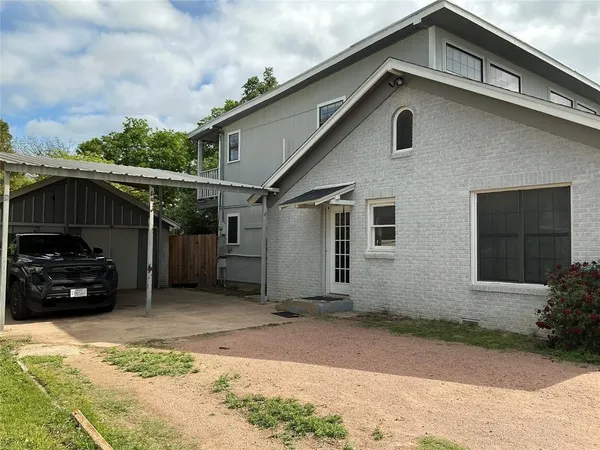 a view of a house with a yard and potted plants