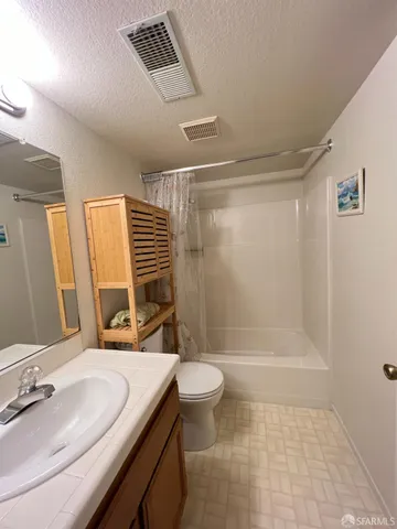 a bathroom with a sink a toilet a mirror and shower