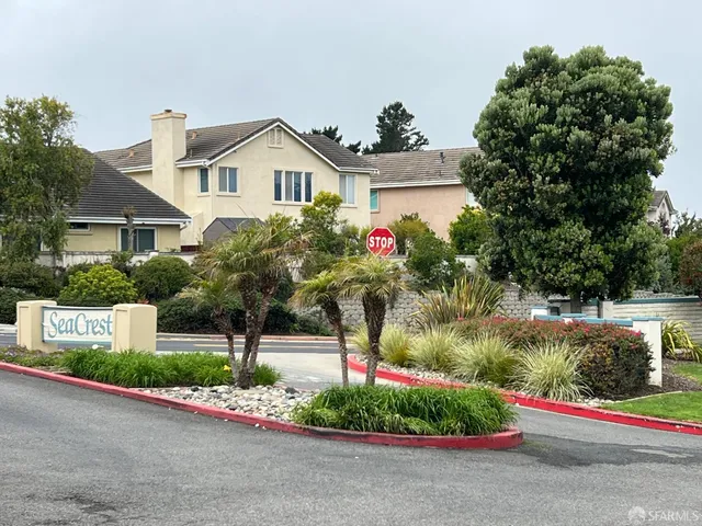 a front view of a house with a yard and potted plants