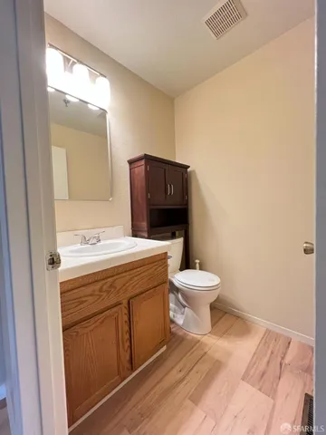 a bathroom with a granite countertop toilet a sink and mirror