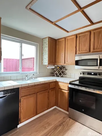 a kitchen with stainless steel appliances granite countertop a sink a stove and cabinets