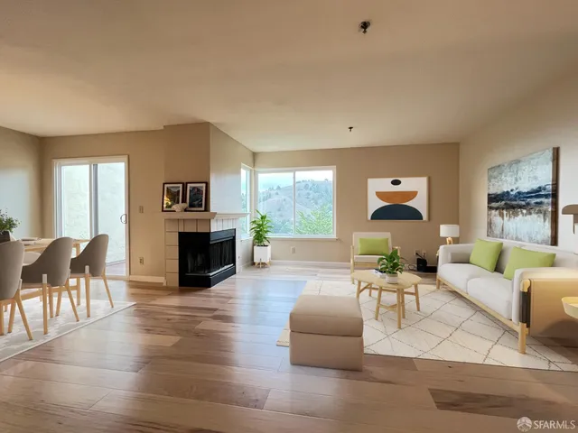 a living room with fireplace furniture and a large window