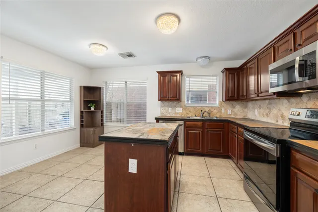 a kitchen with stainless steel appliances granite countertop a stove sink and cabinets