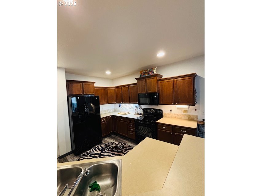 5367 Elk Ridge Drive Eugene, OR 97402 - Photo 23 of 31 a kitchen with stainless steel appliances kitchen island granite countertop a refrigerator and a sink
