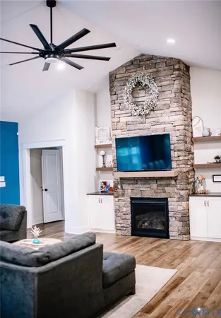 a living room with furniture a flat screen tv and a fireplace