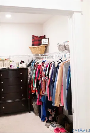 a view of walk in closet with clothes and shoes