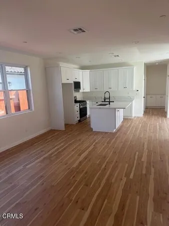 a view of kitchen with wooden floor and electronic appliances