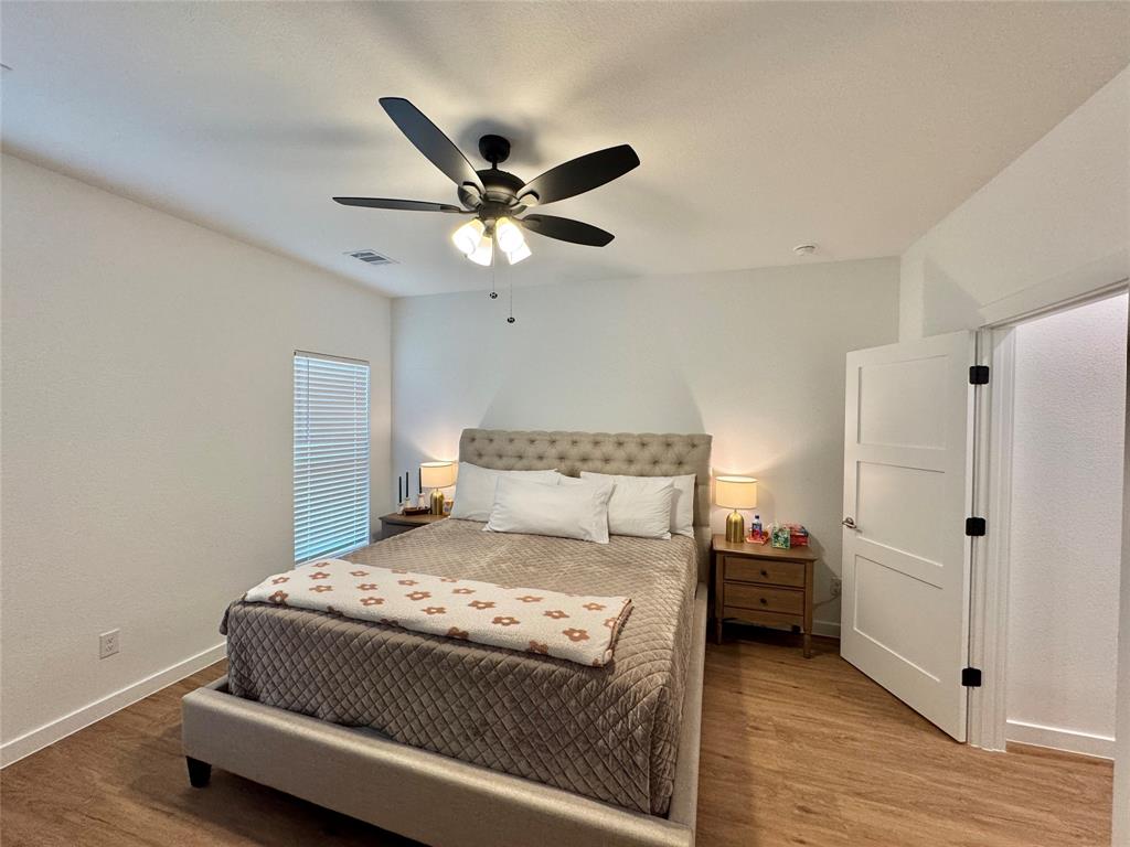 416 Austin Street Gainesville, TX 76240 - Photo 15 of 33 a bedroom with a bed and a ceiling fan