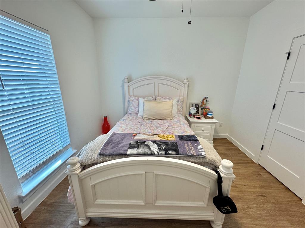416 Austin Street Gainesville, TX 76240 - Photo 21 of 33 a bedroom with a bed and wooden floor