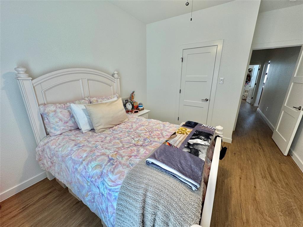 416 Austin Street Gainesville, TX 76240 - Photo 22 of 33 a bedroom with a bed and wooden floor