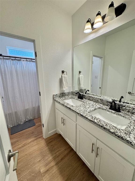416 Austin Street Gainesville, TX 76240 - Photo 25 of 33 a bathroom with a granite countertop sink and a mirror