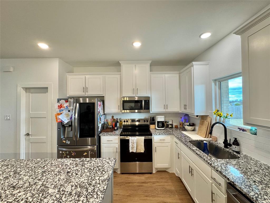 416 Austin Street Gainesville, TX 76240 - Photo 8 of 33 a kitchen with stainless steel appliances granite countertop a stove a sink and a refrigerator