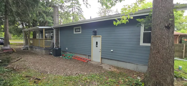 a view of a yard in front of a house with large trees