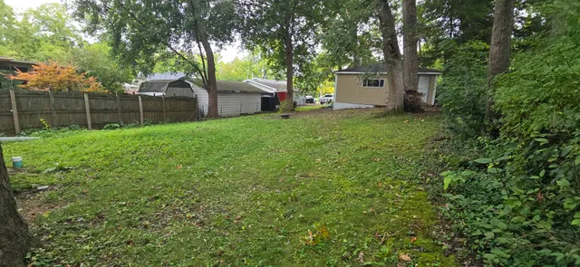 a view of a house with a yard and tree