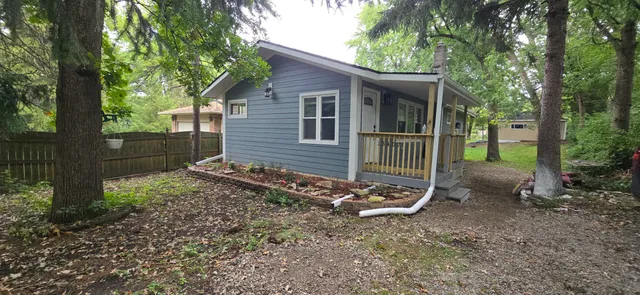 a view of a house with backyard and a tree