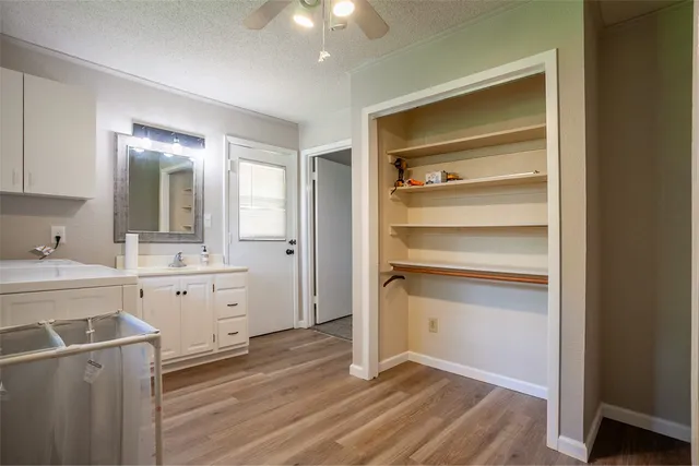 a room with a sink cabinets and wooden floor