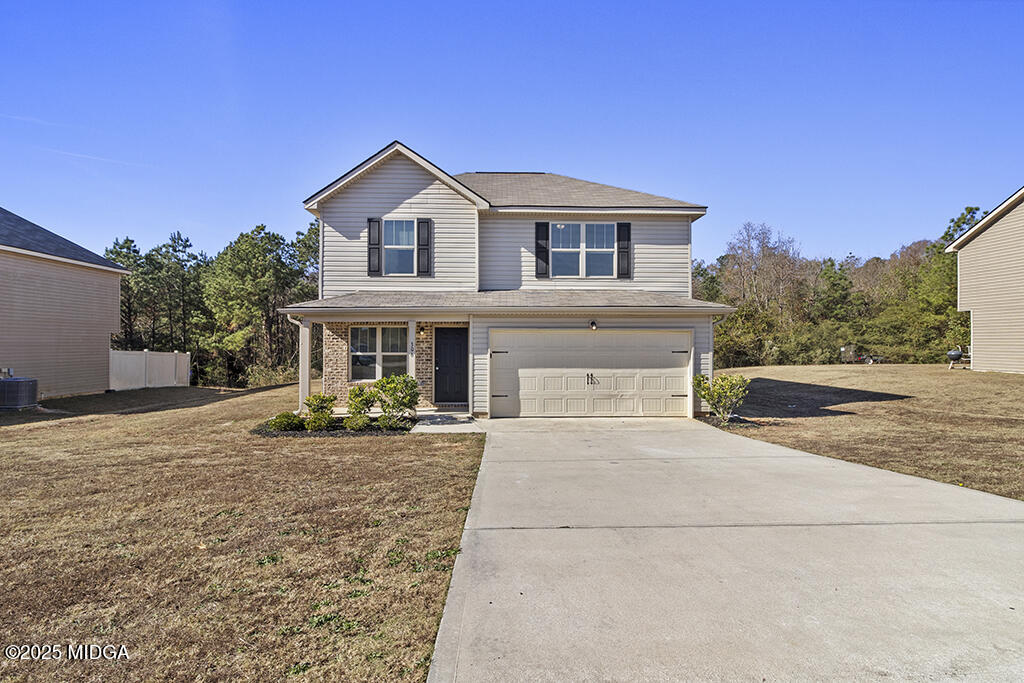 a front view of a house with yard outdoor seating and covered with trees