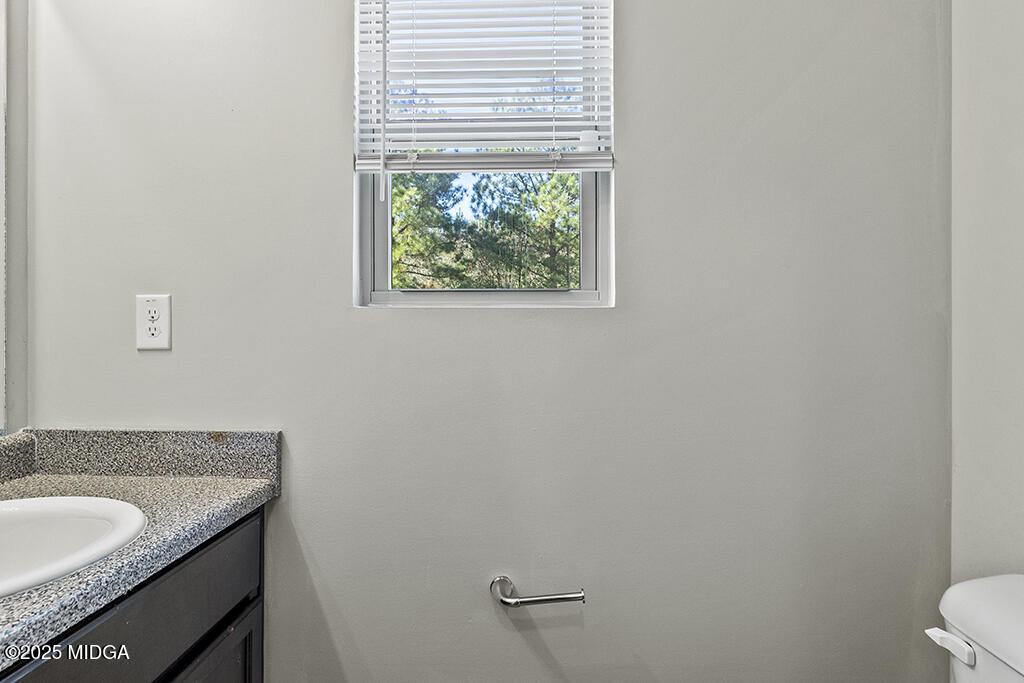 306 Mill Meadow Road Macon, GA 31216 - Photo 15 of 29 a bathroom with a granite countertop sink and a toilet
