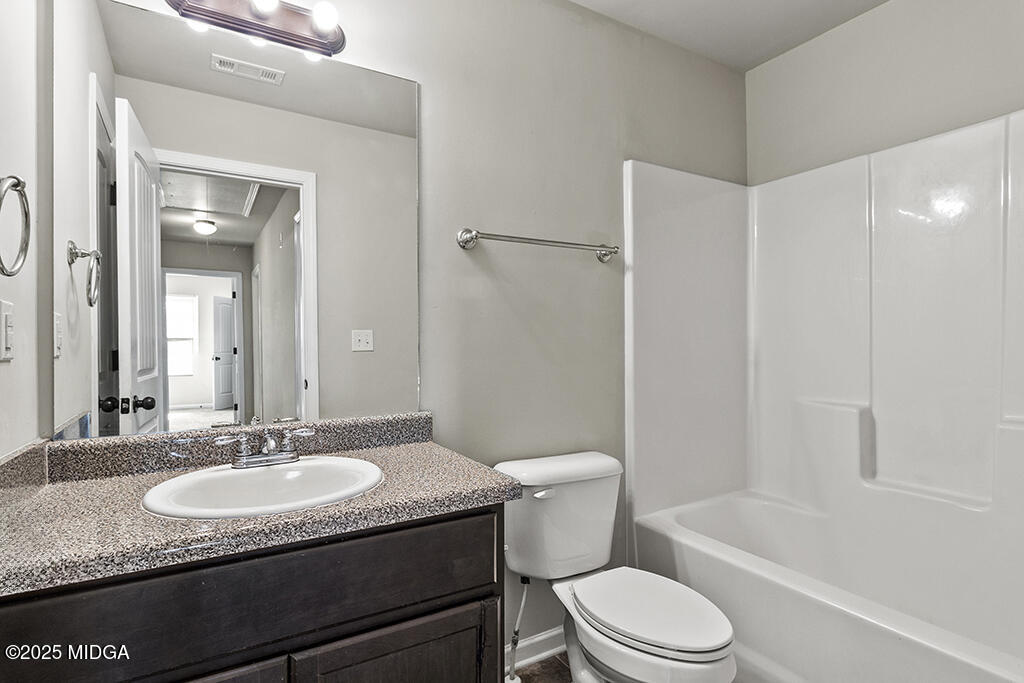 306 Mill Meadow Road Macon, GA 31216 - Photo 28 of 29 a bathroom with a granite countertop sink toilet a mirror and shower