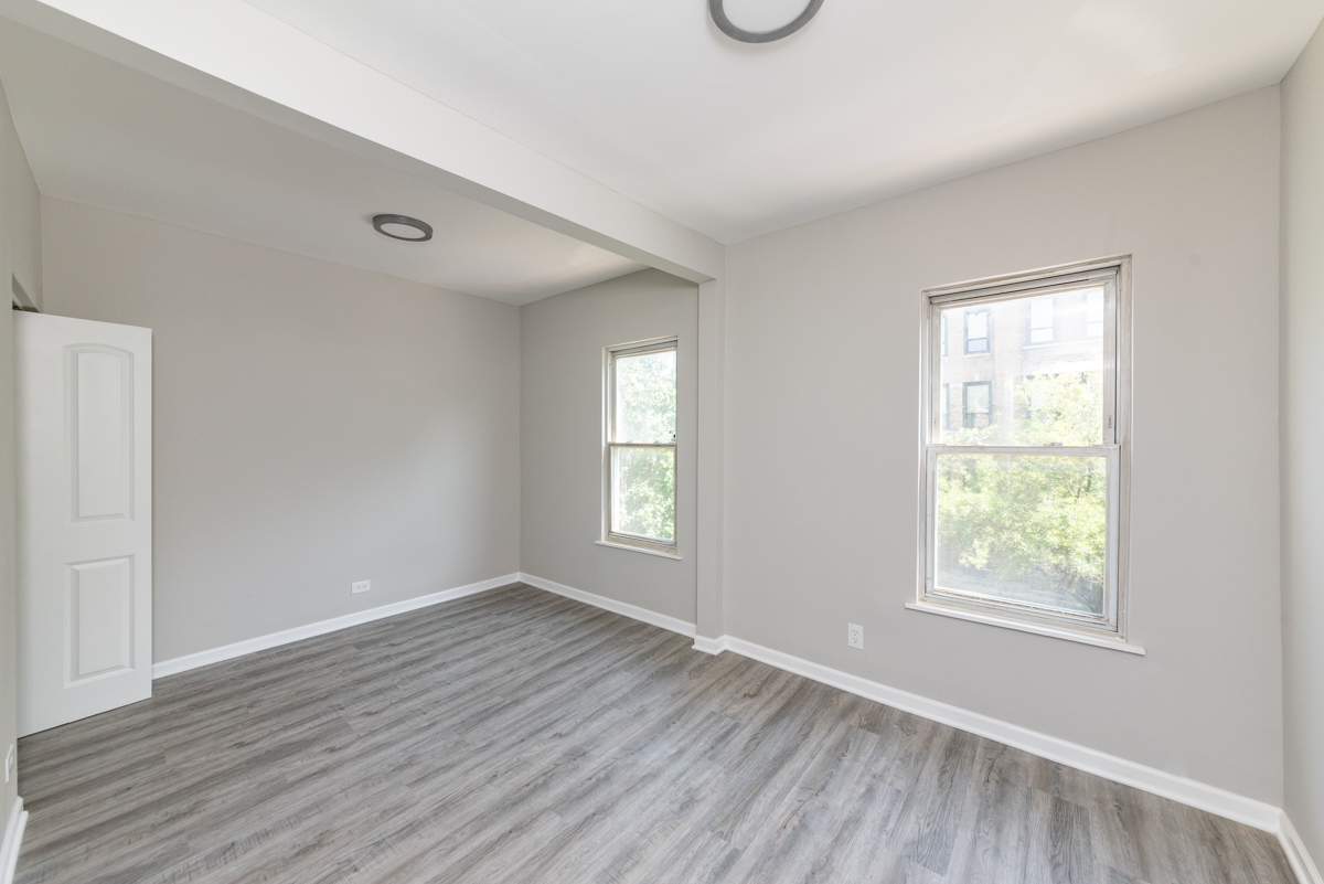 1022 West Fry Street, Unit 2F Chicago, IL 60642 - Photo 6 of 15 an empty room with wooden floor and windows