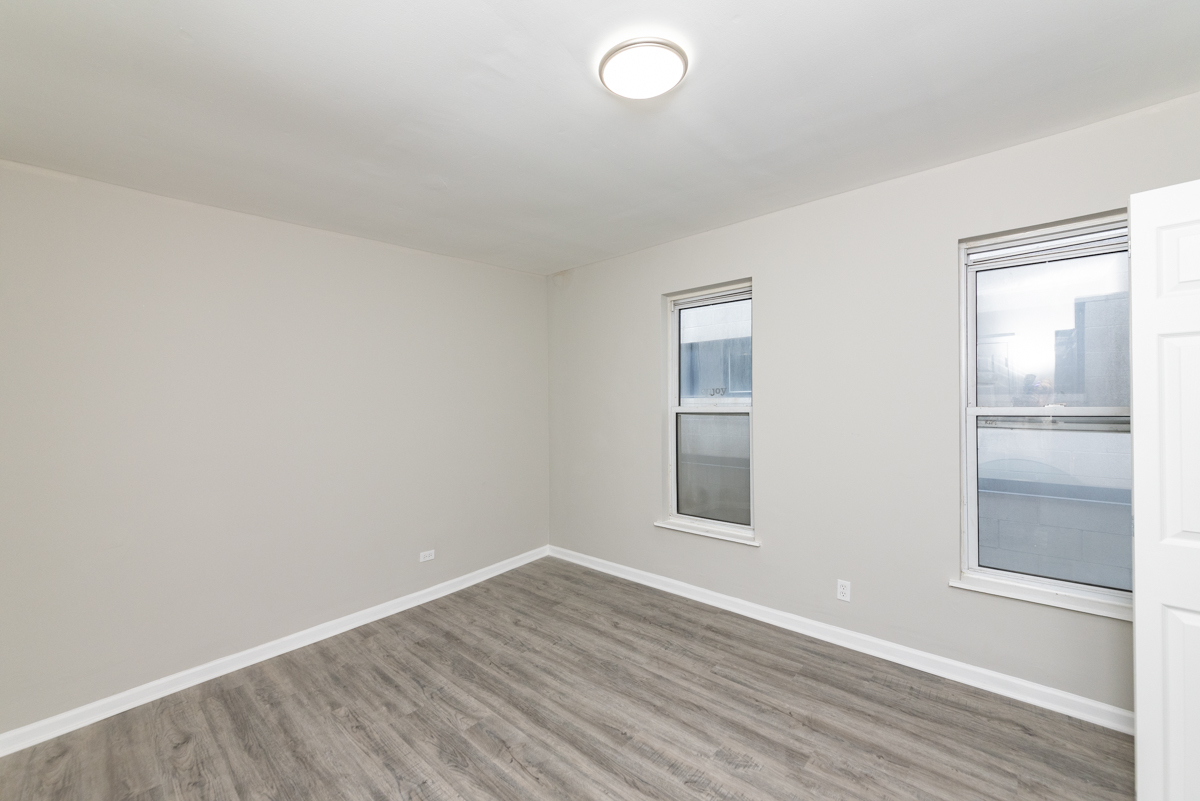 1022 West Fry Street, Unit 2F Chicago, IL 60642 - Photo 9 of 15 an empty room with wooden floor and windows