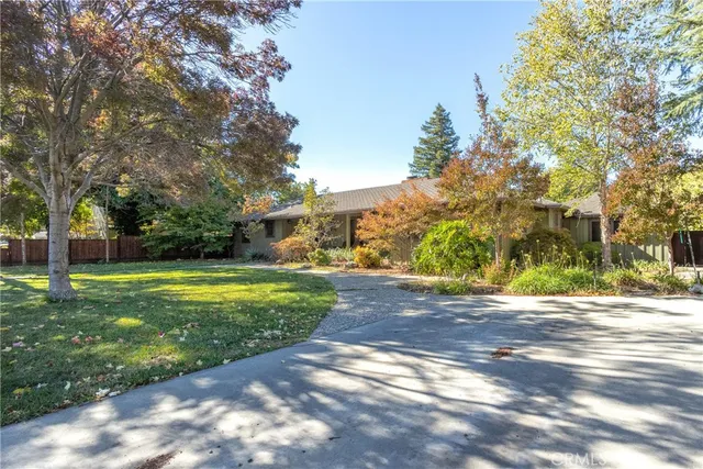 a view of a house with backyard and trees