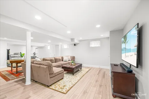 a living room with furniture a flat screen tv and a large window