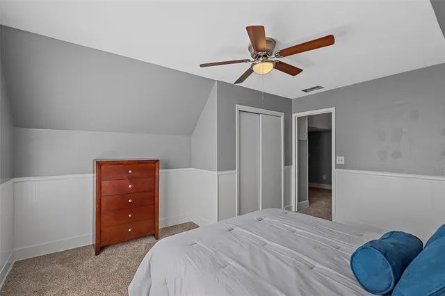 a bedroom with a bed and a ceiling fan