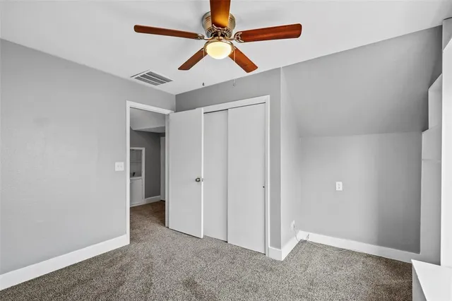 an empty room with chandelier fan