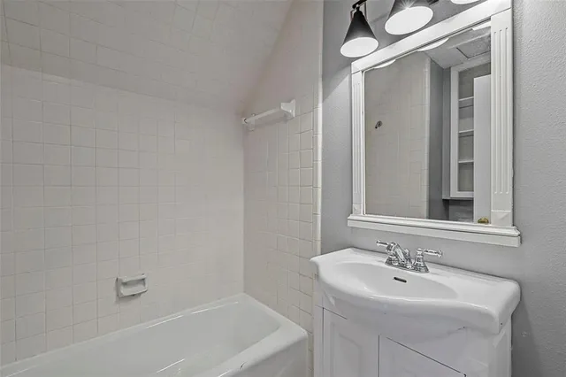 a bathroom with a sink mirror and a bathtub