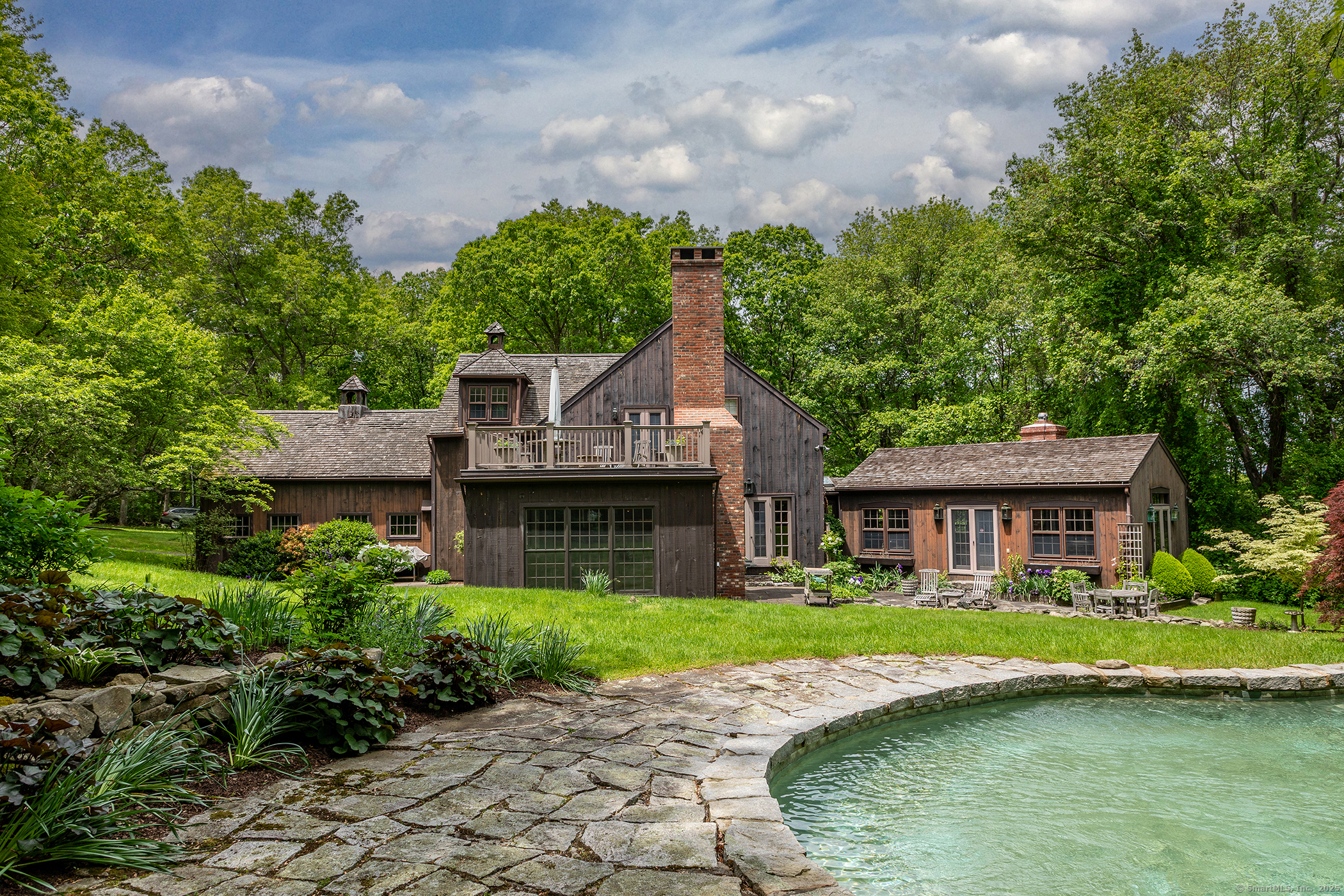 a front view of a house with a garden and swimming pool