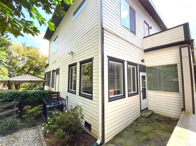 a view of a white house with a potted plant and a large window