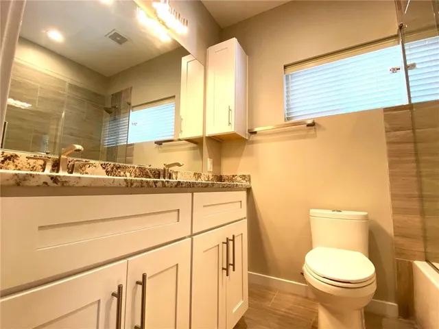 a bathroom with a sink a toilet and a mirror