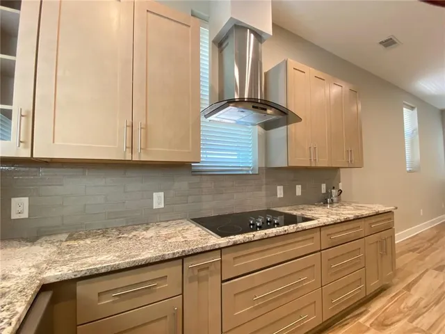 a kitchen with granite countertop white cabinets and a sink