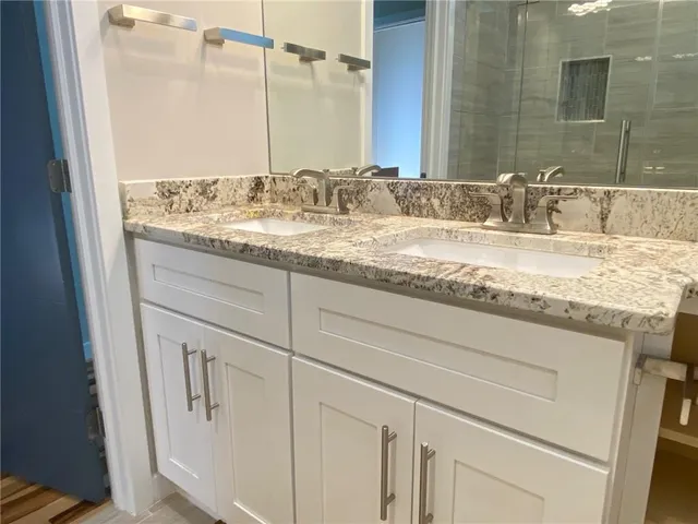 a bathroom with a granite countertop sink and a mirror