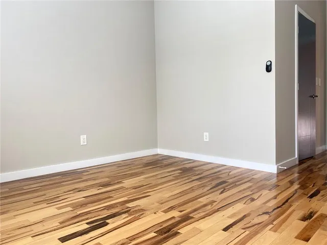 a view of a room with wooden floor and white walls
