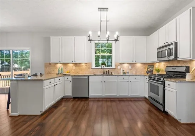 a kitchen with granite countertop wooden floors and white appliances